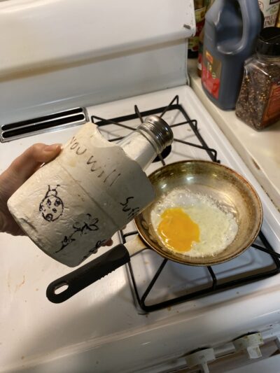 a salt shaker embedded in concrete in front of a frying pan