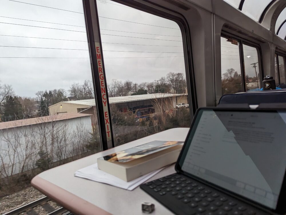 iPad and book on table with building outside a window