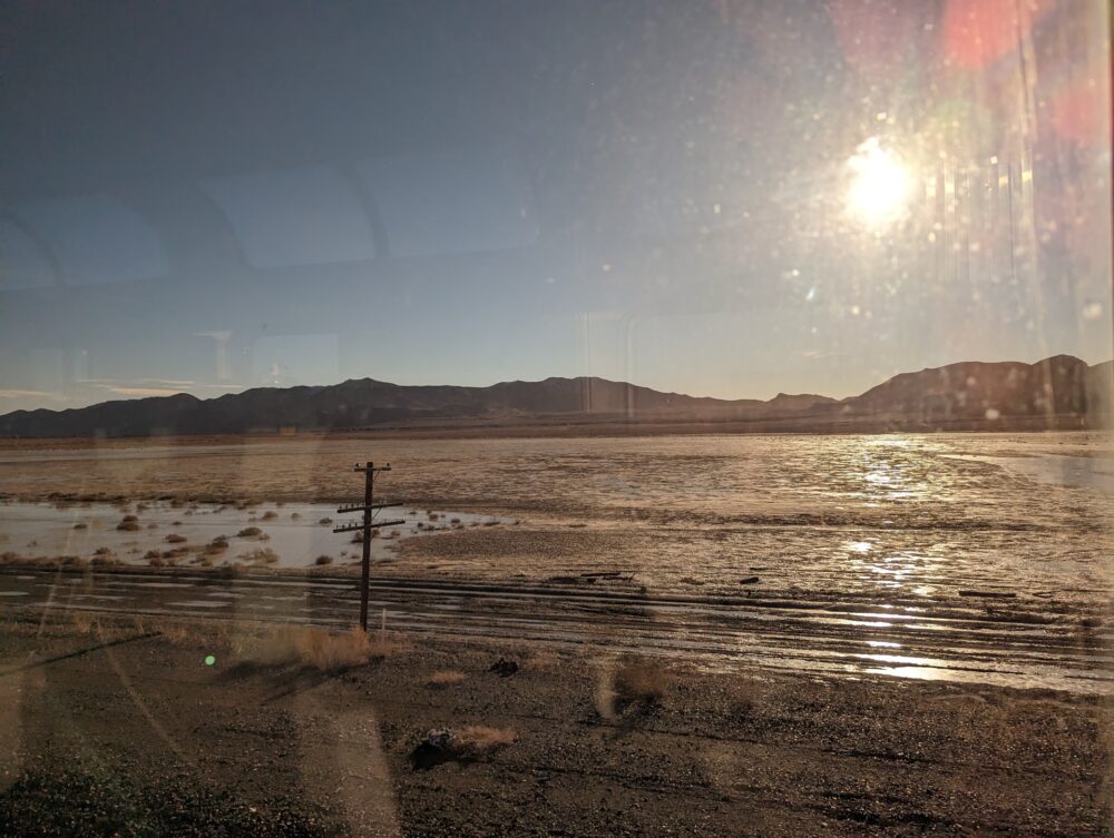 hills above mud flats, with power line strung across