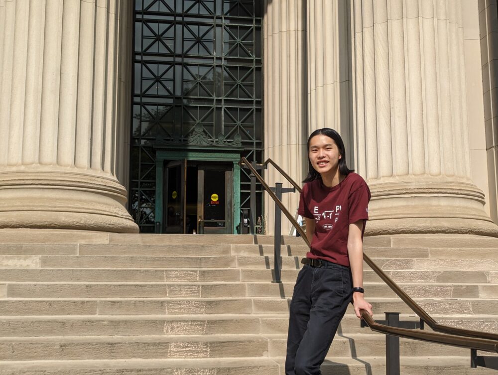 one college student leaning on a handrail in the middle of concrete