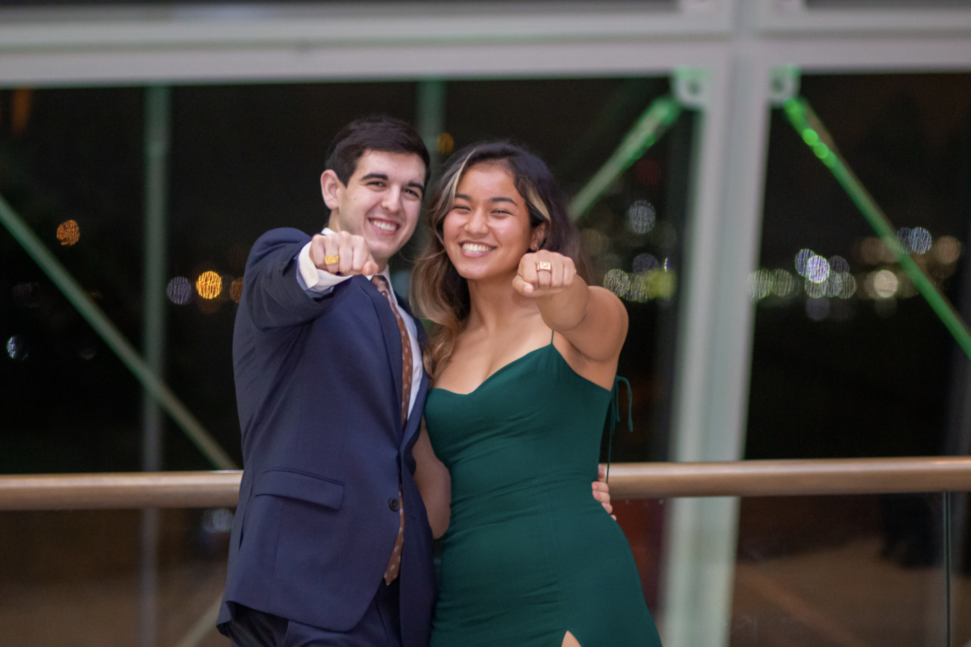 two people showing class rings