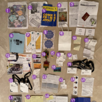 papers, receipts, knick knacks, show programs, playbills, movie tickets, and other trinkets laid out on…